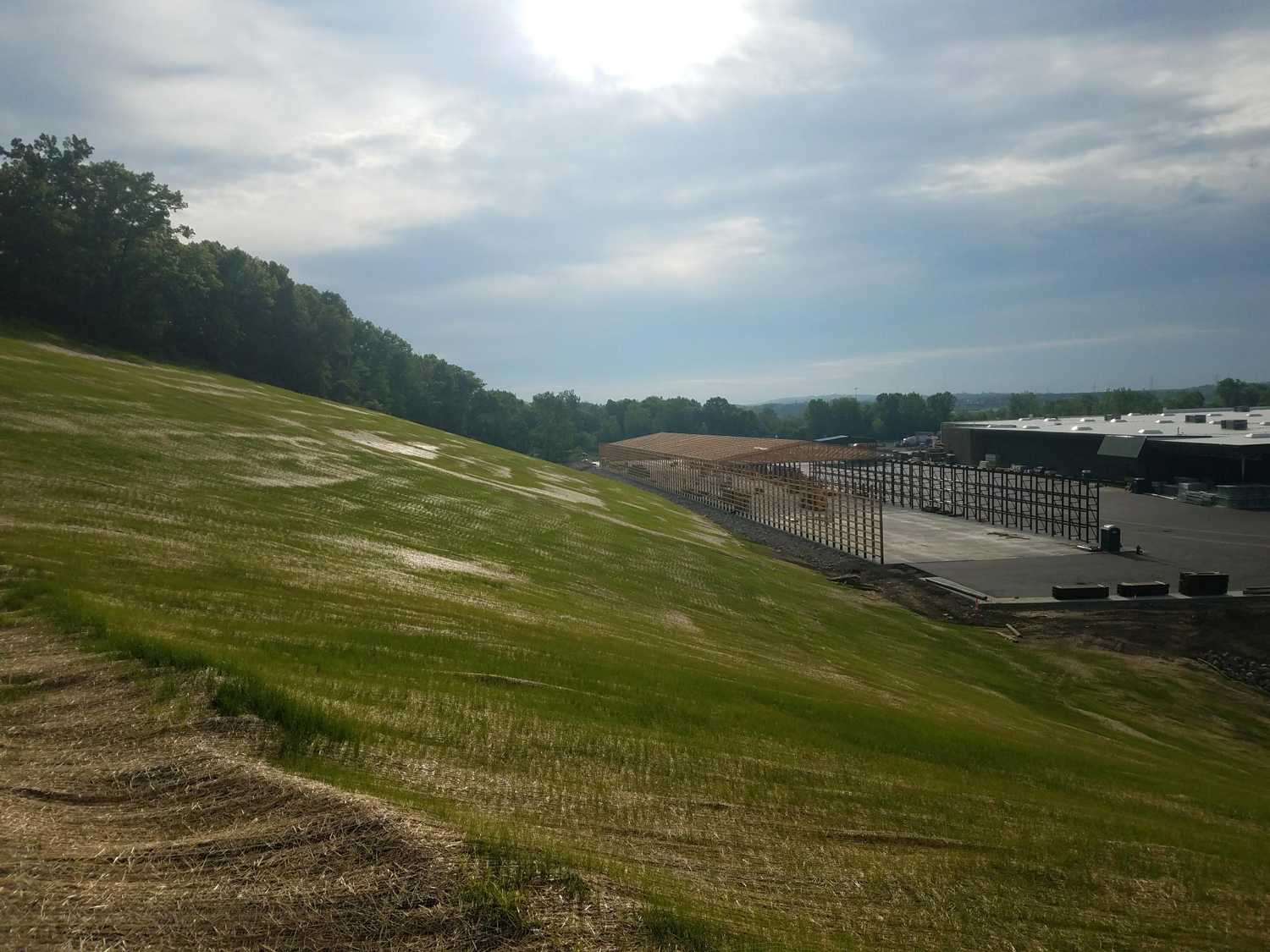 Construction of a parking lot at the Menards Commercial Development with curbing and paving in progress.