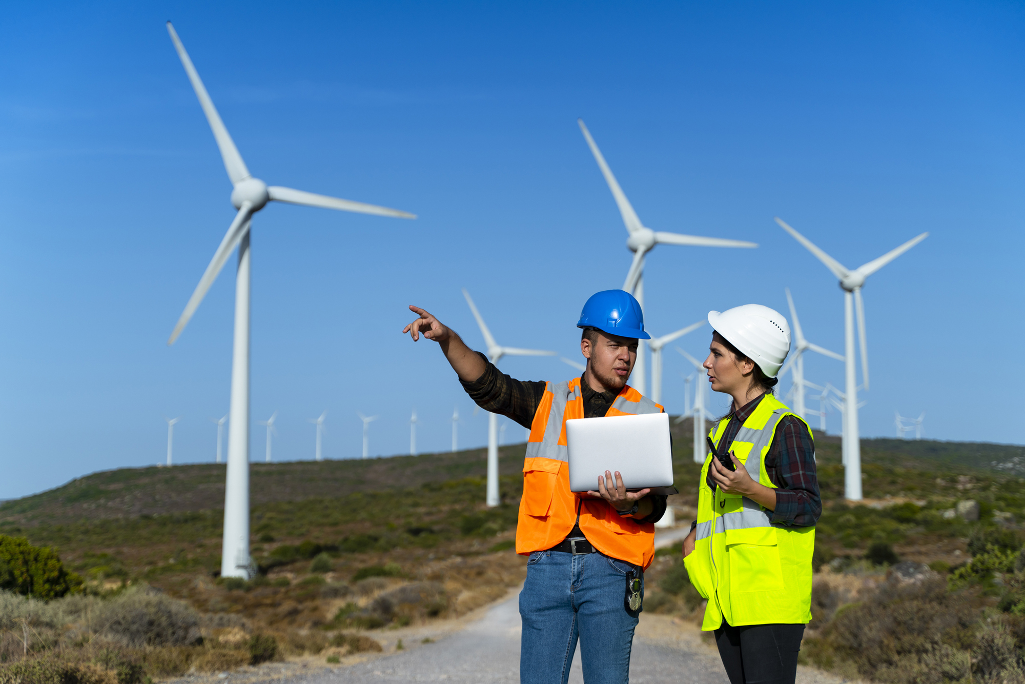 2 field surveyors on site at wind farm discussing the project