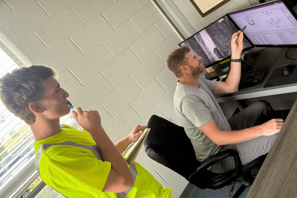 Intern reviewing project details on computer.